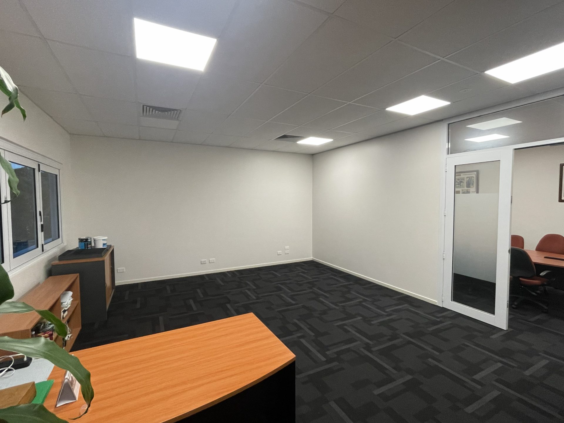 Office with the glazed partition removed, walls patched and carpet reinstated