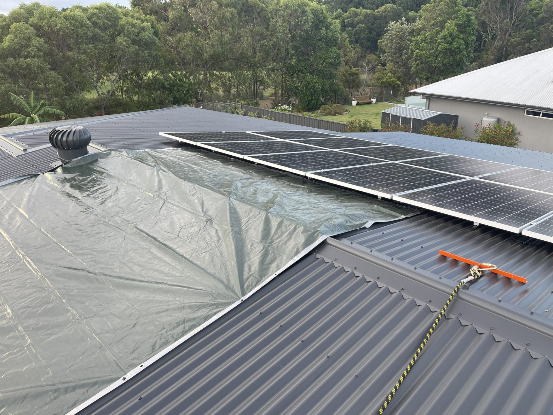 Roof make-safe with tarpaulin battened down over storm damage