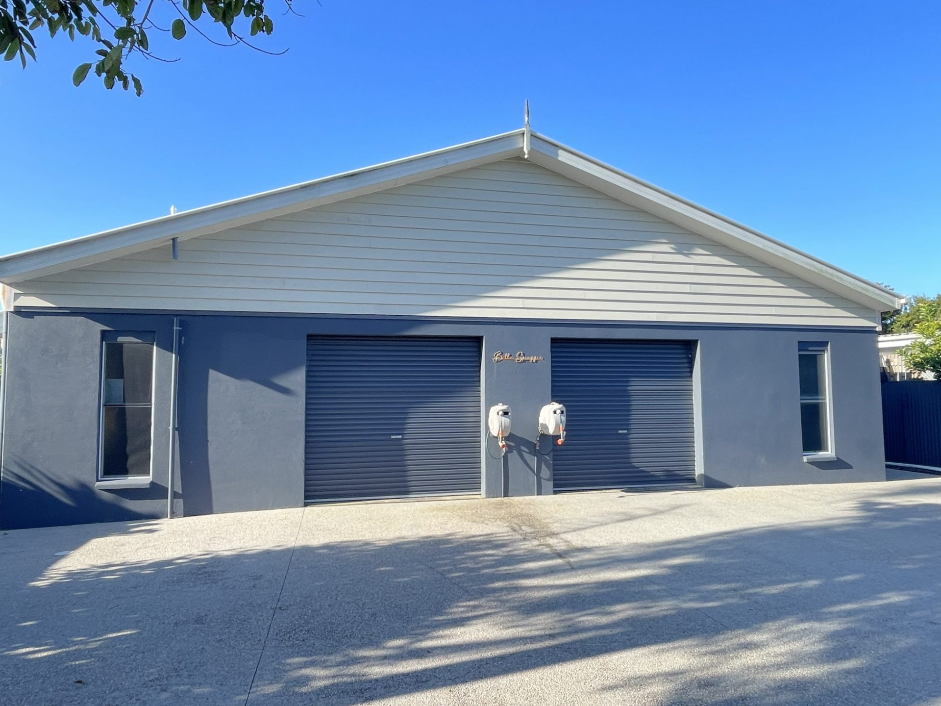 Rendered facade with new cladding and roller doors